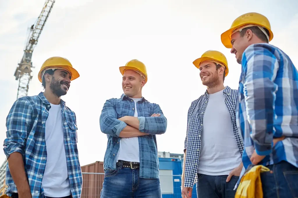 group of smiling builders in hardhats outdoors
